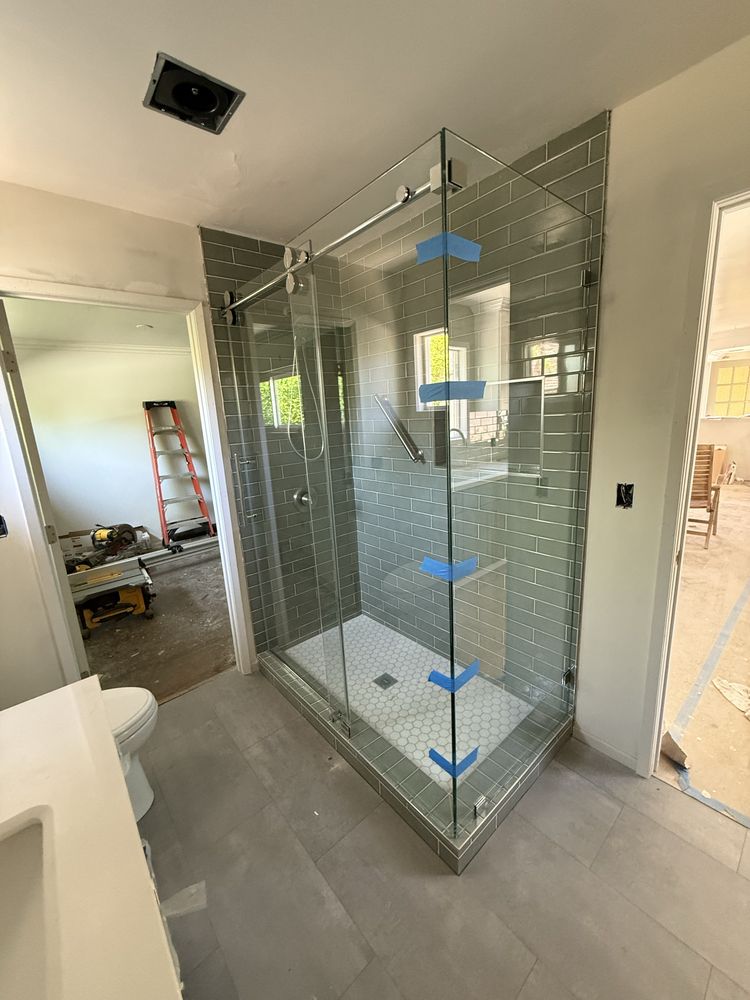 Frameless glass shower enclosure
